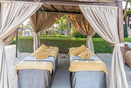 a group of beds sitting under a canopy with curtains at Lux BnB I Palm Jumeirah Resort I Palm Views in Dubai