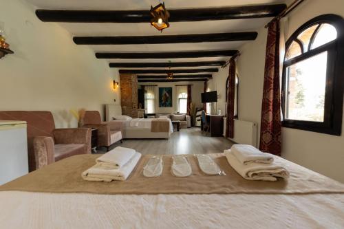 a bedroom with a bed with towels on it at Antique Manastir Boutique Hotel in Edremit
