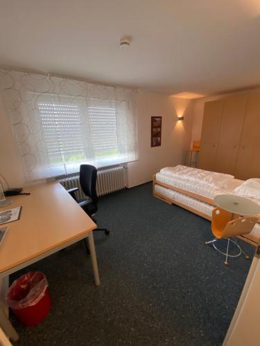 a room with a bed and a desk and chairs at AWM Korntal in Korntal-Münchingen