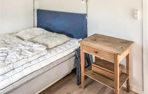 un letto con comodino accanto a un letto con tavolo di Stunning Home In Skagen With 3 Bedrooms And Wifi a Kandestederne