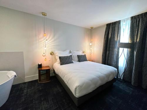 a bedroom with a large white bed and a window at Moulin de Fourges in Fourges