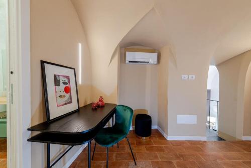 a room with a desk and a green chair at Loft Corso Cavour in Perugia