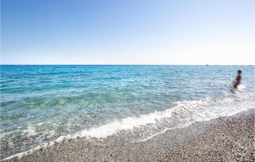 a person walking in the water at the beach at Awesome Apartment In Melito Porto Salvo in Melito di Porto Salvo