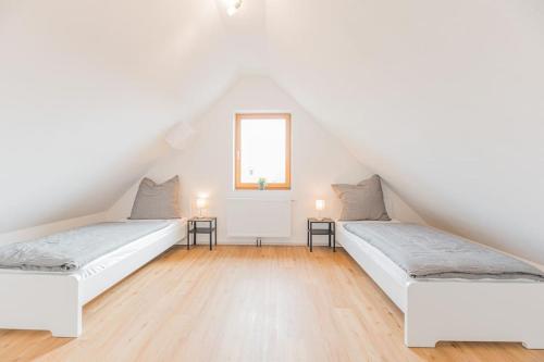 two beds in a room with white walls and wooden floors at G03 große 8er Maisonette Wohnung - ideal für Teams und Monteure - Self Check-In in Gäufelden