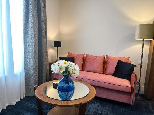 a living room with a couch and a vase of flowers on a table at Moulin de Fourges in Fourges