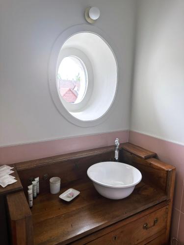 a bathroom with a bowl sink and a mirror at Moulin de Fourges in Fourges