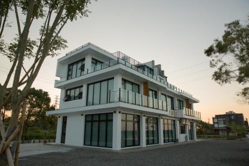 un edificio blanco con muchas ventanas en Golden Harvest Homestay, en Toucheng