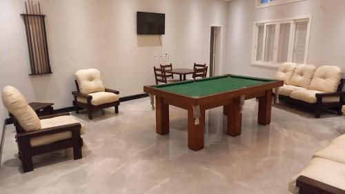 a living room with a pool table and chairs at Hotel Kruger in Tramandaí