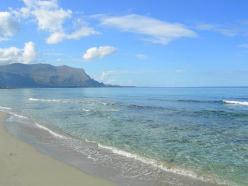 a beach with the ocean and mountains in the background at A casa ru zu Nino in Capaci