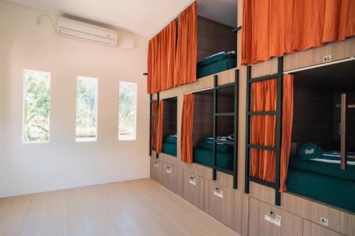 a room with wooden cabinets and windows in a room at The Penida Project in Nusa Penida