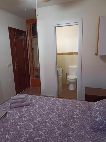 a bedroom with a bed and a bathroom with a toilet at Kiki vivienda Bed & breakfast in San Isidro