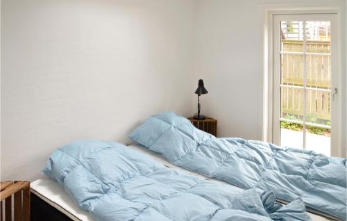 a bed with a blue comforter in a bedroom at Matildes Hus in Skagen