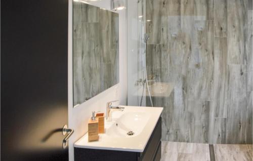 Baño blanco con lavabo y espejo en Matildes Hus, en Skagen