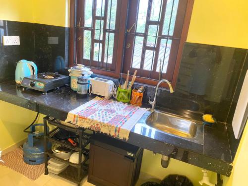 Jayalath Homestay and Apartments في غالي: طاولة مطبخ مع حوض ونافذة