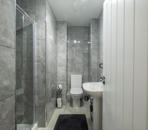 y baño con aseo, lavabo y ducha. en Perfect For Longer Stay, en Great Yarmouth