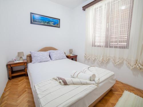 a bedroom with two beds and a window at Rooms Garden in Petrovac na Moru