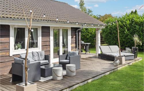 a wooden deck with chairs and a gazebo at Gorgeous Home In Væggerløse With Sauna in Marielyst