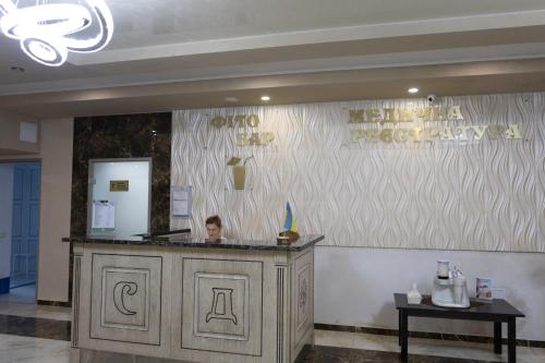 a man sitting at a counter in a restaurant at VitaPark Stariy Dub in Truskavets