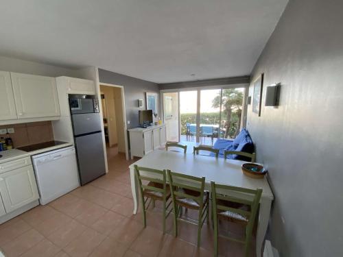 une cuisine et une salle à manger avec une table et des chaises dans l'établissement Appartement T3 belle terrasse avec vue sur le port de la Coudouliere, à Six-Fours-les-Plages