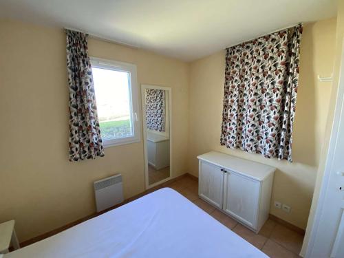 une chambre avec un lit et une fenêtre avec des rideaux dans l'établissement Appartement T3 belle terrasse avec vue sur le port de la Coudouliere, à Six-Fours-les-Plages