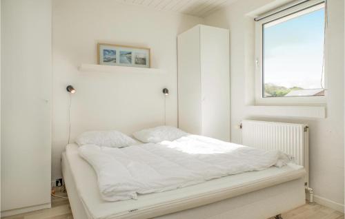 Cama blanca en habitación con ventana en Nice Home In Blokhus With Sauna, en Blokhus