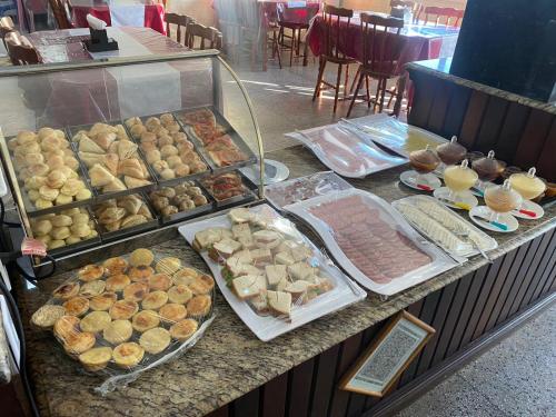 een buffet met verschillende soorten eten op de balie bij Hotel Kruger in Tramandaí