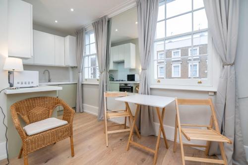 cocina y comedor con mesa y sillas en Stylish first floor 1BR flat in Notting Hill, en Londres