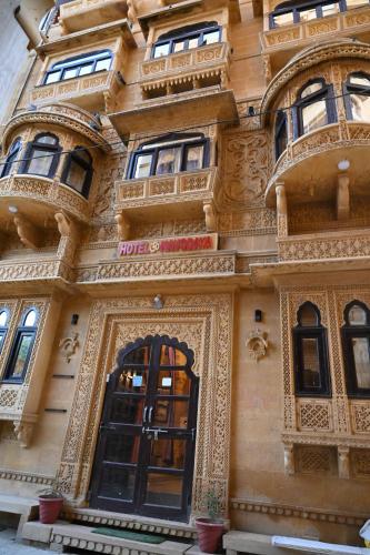 ein verziertes Gebäude mit einer Tür und Fenstern in der Unterkunft Hotel Navodaya Jaisalmer in Jaisalmer