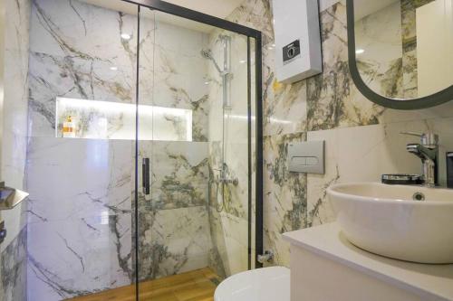 La salle de bains est pourvue d'un lavabo et d'une douche en verre. dans l'établissement 1+1 Apartment in Elite City, à Alanya