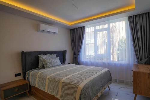 - une chambre avec un lit et une grande fenêtre dans l'établissement 1+1 Apartment in Elite City, à Alanya