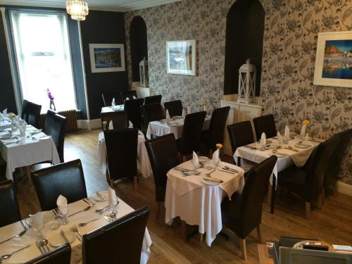 a dining room with tables and chairs in a restaurant at The Davron Hotel in Fraserburgh