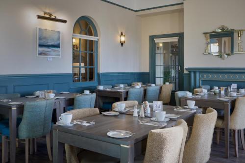 a dining room with wooden tables and chairs at The Lansdowne, Eastbourne in Eastbourne