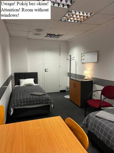 a room with two beds and a table and chairs at Aleja "Solidarności" in Warsaw
