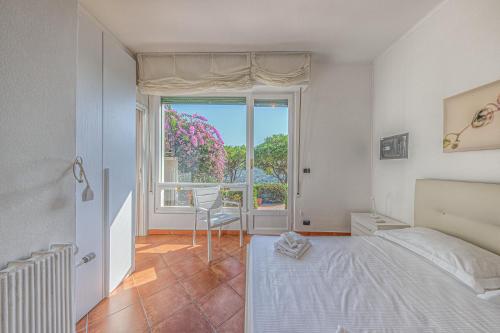 a bedroom with a bed and a large window at Villa Orchidea by PortofinoHomes in Santa Margherita Ligure