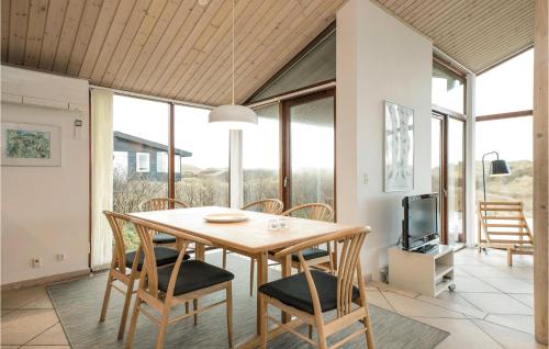 a dining room with a table and chairs and a tv at Holiday Home Ruthsvej in Grønhøj