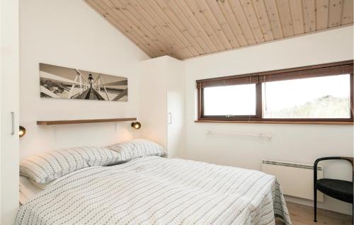 a white bedroom with a bed and a window at Holiday Home Ruthsvej in Grønhøj