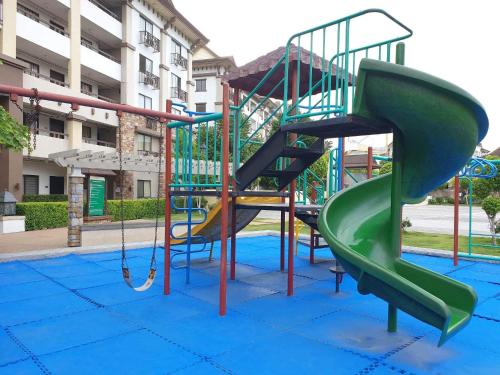 a playground with a slide on a blue surface at One Oasis Condominium 2 Bedroom in Davao City