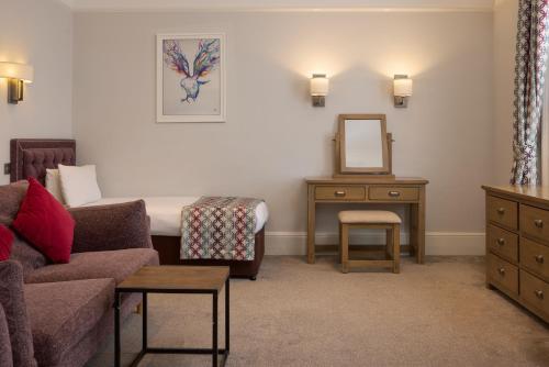 a living room with a couch and a mirror at The Lansdowne, Eastbourne in Eastbourne