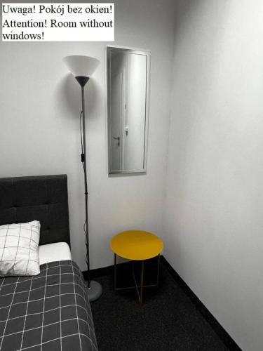 a bedroom with a yellow table and a mirror at Aleja "Solidarności" in Warsaw