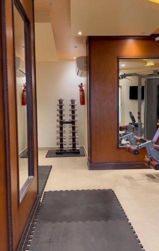 a hallway with a gym with a mirror and a treadmill at Levant Hotel فندق قصر المشرق in Najran