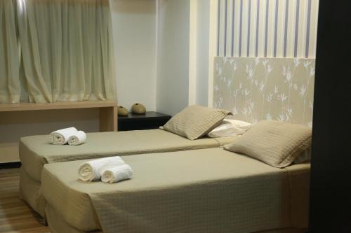 two beds in a room with towels on them at Arrey Executive Hotel in Teresina