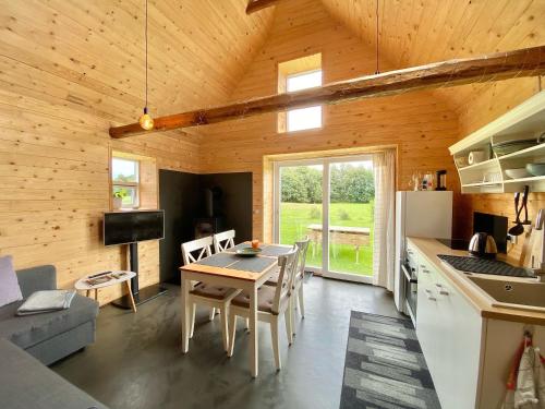 a kitchen and living room with a table in a cabin at Hyggehytten auf Bornholm in Østermarie