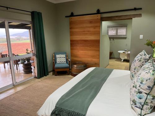 een slaapkamer met een bed en een glazen schuifdeur bij Ploughman’s Rest in Ohrigstad