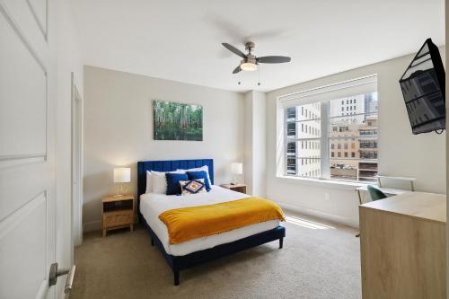 a bedroom with a blue bed and a window at Modern Condo Walking Distance to Must-See Attractions of NOLA in New Orleans