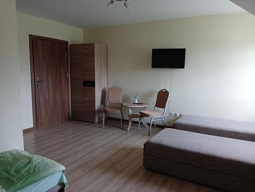 um quarto de hotel com uma cama, uma mesa e cadeiras em Hotel Romantyczny em Miedzyrzec Podlaski