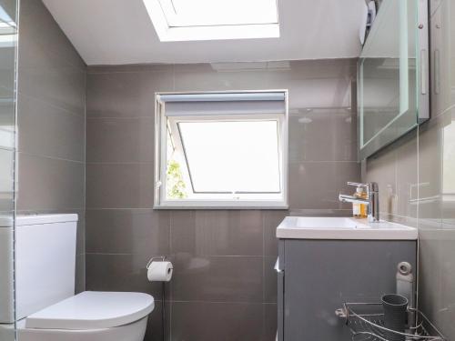 a bathroom with a toilet and a window at Palm Court in Carnforth