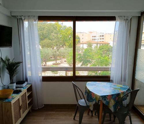 une salle à manger avec une table et une grande fenêtre dans l'établissement Deux pièces climatisé avec balcon Vieil Antibes, à Antibes