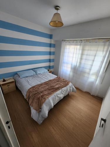 1 dormitorio con 1 cama con rayas azules y blancas en NUEVO APART 2/4 PERSONAS ZONA TEATROS EXCELENTE UBICACION en Buenos Aires