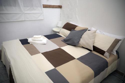 Cama con manta y almohadas a cuadros en Marinai Home, en Catania