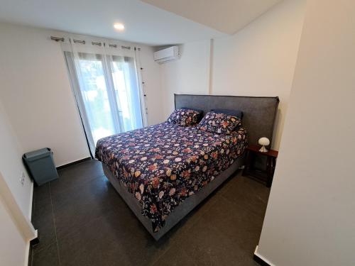 a bedroom with a bed and a large window at Villa Pluton - Meublé de tourisme 4 étoiles in Saint-Gilles les Bains